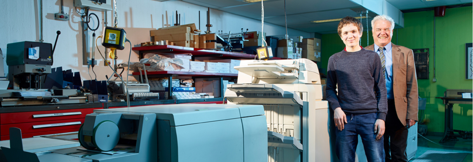 Mitarbeiter mit Schwerbehinderung an einer Werkstattmaschine mit seinem Vorgesetzen